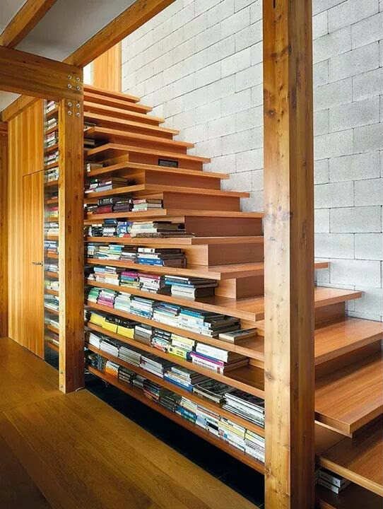 Escalera biblioteca decorada con libros y plantas verdes